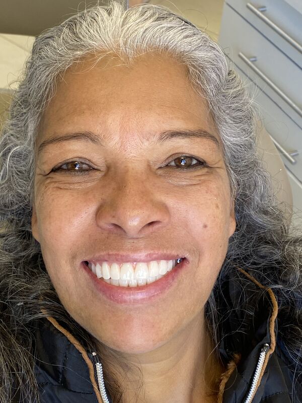 Paciente da A&A Dental Clinic sorrindo no consultório